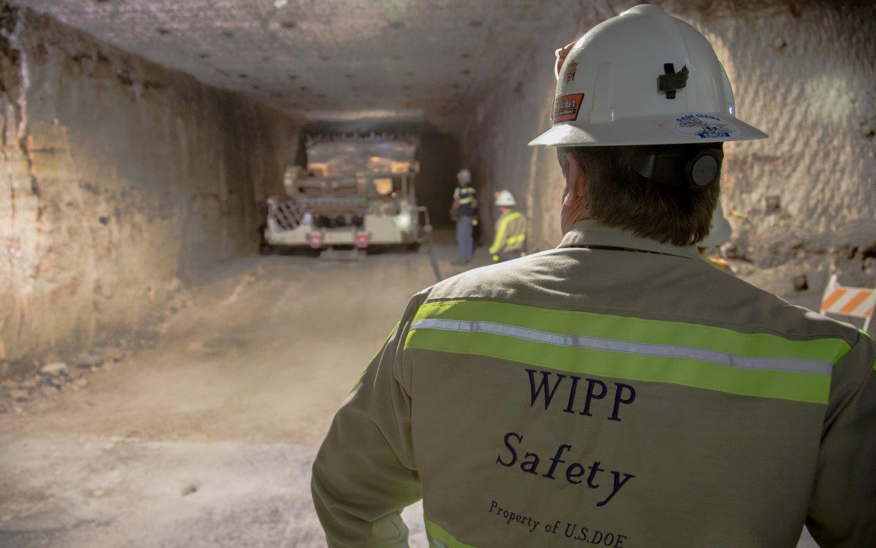 photo of a continuous mining machine observed by fellow miners short angle view